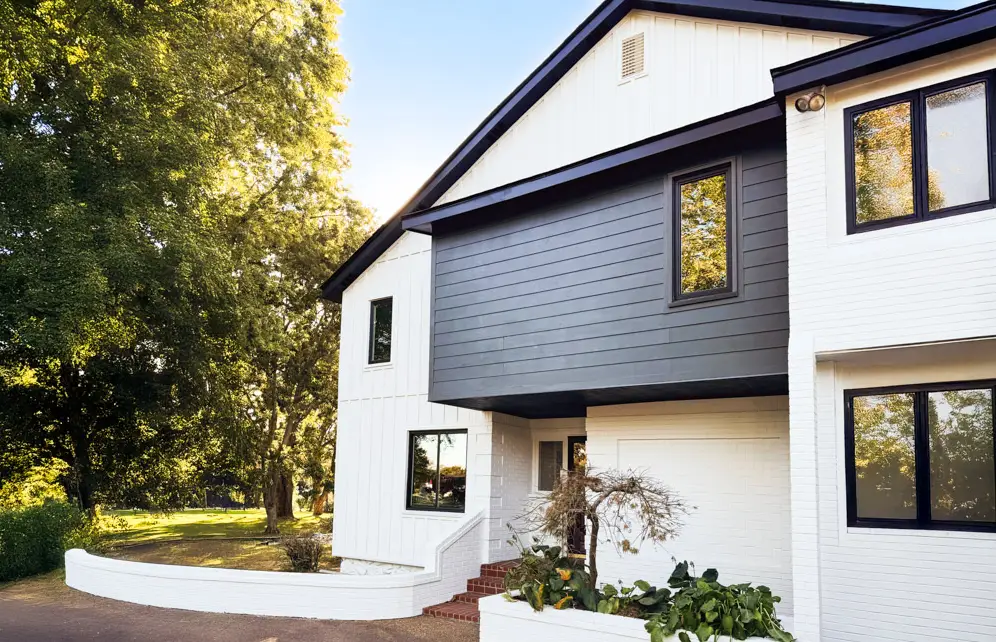 Modern white home completed with new siding installation and painted masonry